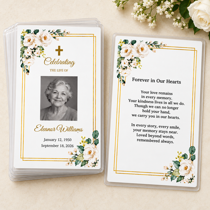 Stack of personalized white rose and gold laminated memorial prayer cards beside the Forever in Our Hearts back